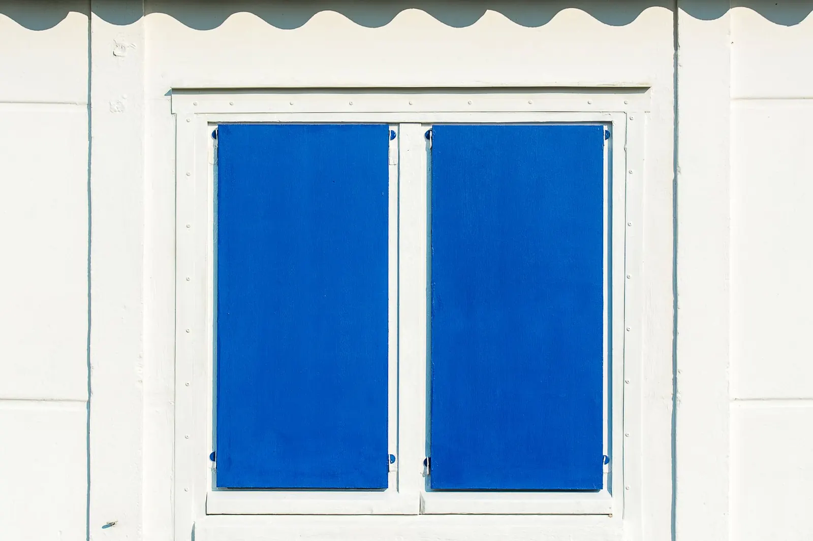Closed window shutters on a white wall