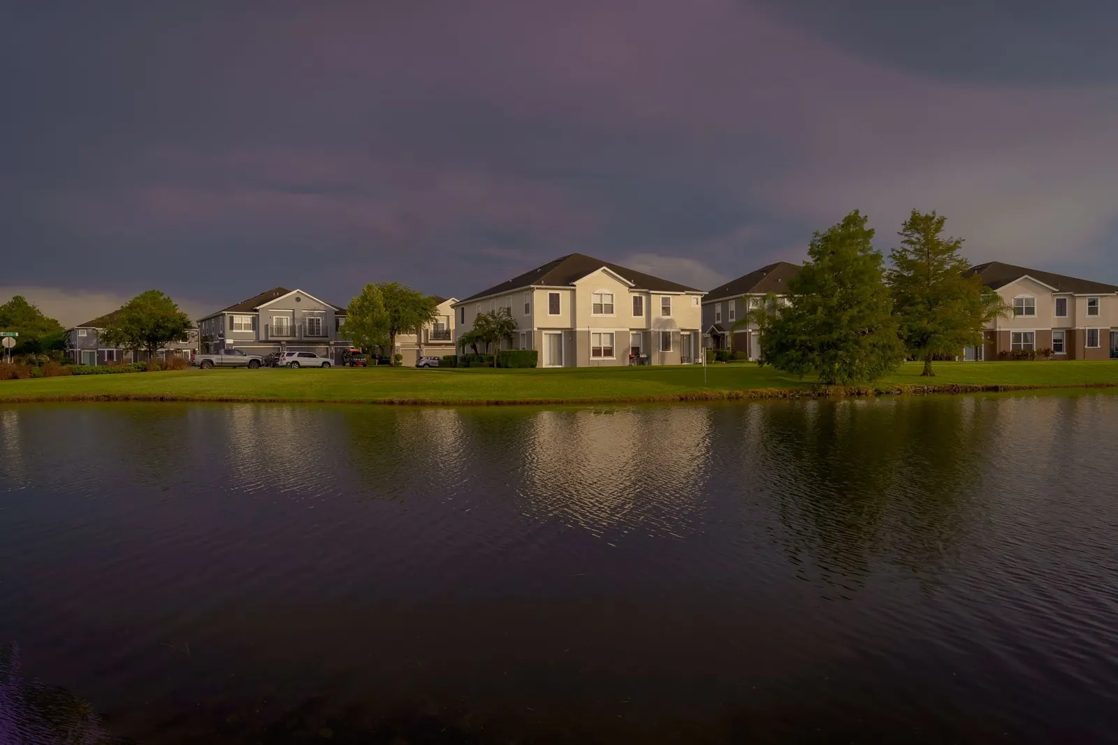Suburban homes along a pond at dusk
